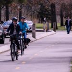 two man and woman riding bicycles on road