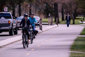 two man and woman riding bicycles on road
